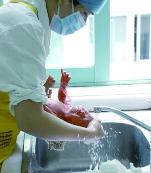 护士正在为新生儿洗澡。 护士正在为新生儿洗澡。