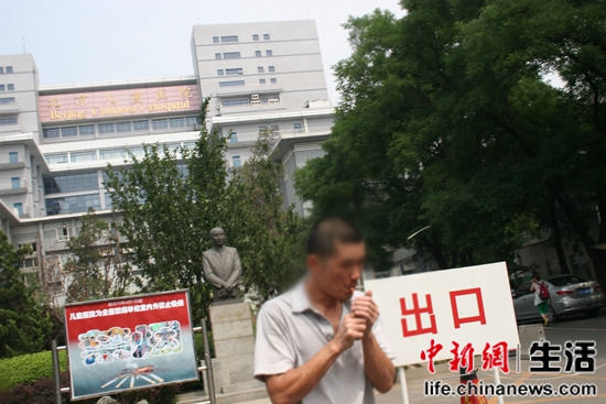 北京儿童医院,一位男士正在抽烟,他的身后是禁烟标识。 北京儿童医院,一位男士正在抽烟,他的身后是禁烟标识。