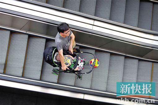 昨天,广州花城广场,一位男子抱着婴儿车在搭乘手扶电梯。新快报记者 宁彪/摄 昨天,广州花城广场,一位男子抱着婴儿车在搭乘手扶电梯。新快报记者 宁彪/摄